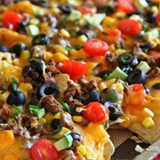 Loaded Nachos With  Shredded Cheese, Black Olives, Avocados, Tomatos, Refried Beans, & Jalapenos
