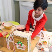 Kid Building a Gingerbread House
