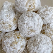 Powdered Sugar Pumpkin Round Donut With Blue Drizzle, and Shaved Coconut