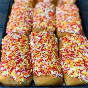 Vanilla Iced and Strawberry-Filled Chocolate Long John With Sprinkles