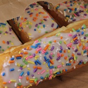 Vanilled Iced Pumpkin Long John With Blue Drizzle and Sprinkles