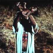 Roots: Part I: Newborn Kunta Kinte Held Aloft by His Father