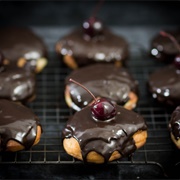 Chocolate Iced and Chocolate-Filled Chocolate Round Donut With Vanilla Drizzle