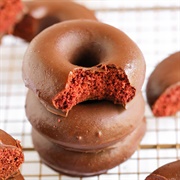 Chocolate Iced Red Velvet Ring Donut With Caramel Drizzle and Crushed Peanuts