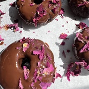 Rose Iced and Strawberry-Filled Chocolate Round Donut With Coconut