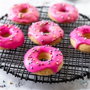 Rose Iced and Chocolate-Filled Pumpkin Ring Donut With Sprinkles