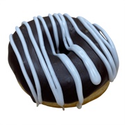 Vanilla Iced Chocolate Ring Donut With Blue Drizzle and Chocolate Drizzle