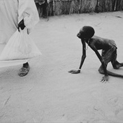 A Well-Nourished Sudanese Man Steals Maize From a Starving Child... (Tom Stoddart)
