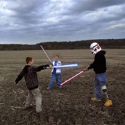 Raymond Plays With Star Wars Lightsabers With His Sons Brady and Riley (Peter Van Agtmael)