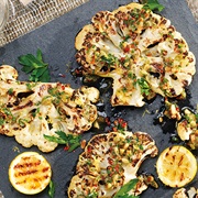 Grilled Cauliflower With Caper, Pine Nut, and Raisin Dressing