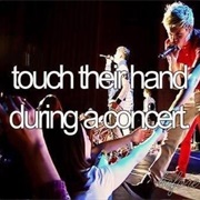 Touch Their Hand During a Concert